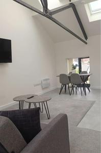 sala de estar con sofá, mesa y sillas en Modern Loft Apartment, en Rotherham