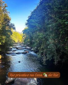 une rivière avec des rochers et des arbres sur le côté dans l'établissement Casa do Rio - Lumiar, à Lumiar