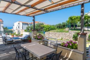 a patio with a table and chairs and a stone wall at Apartments with a parking space Tucepi, Makarska - 6856 in Tučepi