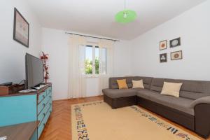 ein Wohnzimmer mit einem Sofa und einem TV in der Unterkunft Apartments with a parking space Tucepi, Makarska - 6856 in Tučepi
