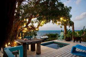 a wooden deck with a table and chairs and the ocean at Golden Sea Casa Boutique in Archibolds