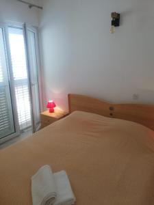 a bedroom with a bed with a lamp and a window at Apartments by the sea Pisak, Omis - 652 in Mimice