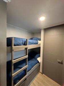 mały pokój z łóżkiem piętrowym i drzwiami w obiekcie Departamento en pucon w mieście Pucón