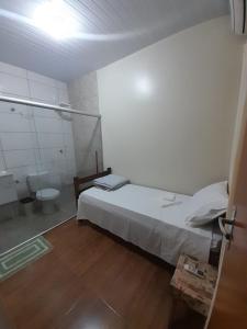 um quarto com uma cama e uma casa de banho com um WC em Hostel Casa Uniao em Maracaju