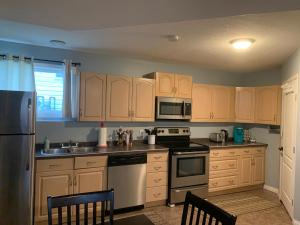 a kitchen with wooden cabinets and stainless steel appliances at Cozy Basement Suite close to Downtown,Edmonton in Edmonton +20 photos