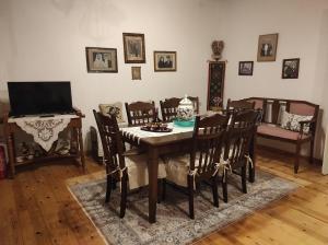 een eetkamer met een tafel en stoelen en een televisie bij Rita' s House Glossa Skopelos in Glóssa