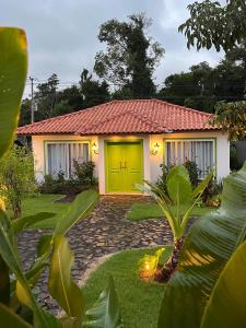 a house with a yellow door in a yard at Alma Iguassu in Foz do Iguaçu