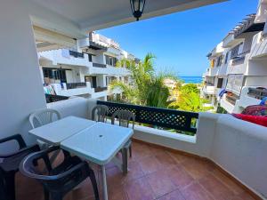 balcón con mesa, sillas y vistas al océano en Résidence Jawhara, luxe, piscine et en face à la mer en Oued Laou
