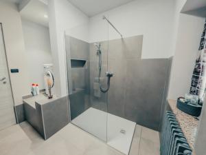 una doccia con porta in vetro in bagno di Casa Calandri - Elegante Appartamento Free Wi-FI a Margarita