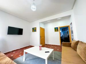Residence Al Kasaba - Spacious apartment with swimming pool and direct access to sea的电视和/或娱乐中心
