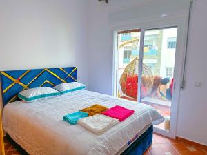 拉乌Residence Al Kasaba - Spacious apartment with swimming pool and direct access to sea的一间卧室，床上有一张带毛巾的床