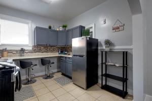 a kitchen with blue cabinets and a stainless steel refrigerator at Midtown Beauty in Memphis