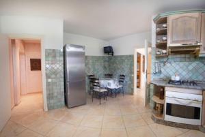 a kitchen with a stainless steel refrigerator and a table at Bord de mer, villa de luxe in Tamaris