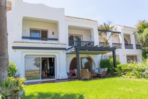 a white house with a balcony and a yard at Bord de mer, villa de luxe in Tamaris