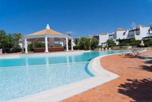 a swimming pool with a gazebo in a resort at Bord de mer, villa de luxe in Tamaris