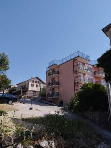 a pink apartment building with a parking lot at Apartments by the sea Podaca, Makarska - 21547 in Zaostrog