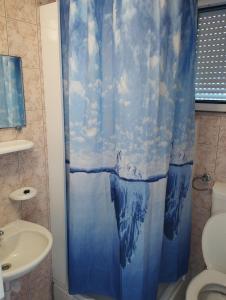 a bathroom with a blue shower curtain with a dolphin at Apartments by the sea Podaca, Makarska - 21547 in Zaostrog
