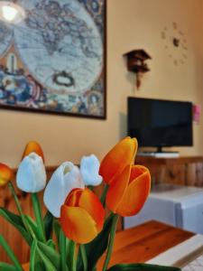 a vase with orange and white flowers on a table at Il Posticino Di Bellagio in Civenna