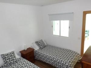 Schlafzimmer mit einem Bett und einem Fenster in der Unterkunft Vivienda Vacacional El Roquete in Punta del Hidalgo