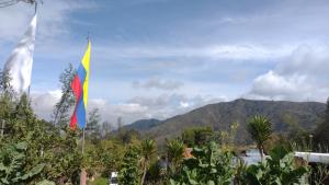 a flag on a pole with mountains in the background at Casa Indigena de la Paz Shinawindua in Bogotá