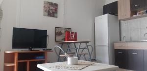 uma cozinha com uma televisão e uma mesa com um banco em City Park Skopje apartment em Skopje