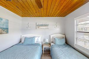2 Betten in einem Schlafzimmer mit Holzdecke in der Unterkunft Lake June Resort #9 in Lake Placid