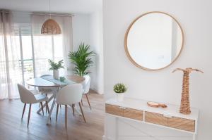 a dining room with a table and a mirror at Ítaca Apartments Peñiscola - Cerromar in Peniscola +19 photos