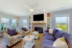a living room with a couch and a fireplace at Compass Rose in Topsail Beach