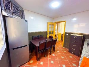 a kitchen with a table and a refrigerator at Residence Al Kasaba - Spacious apartment with swimming pool and direct access to sea in Oued Laou