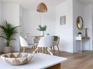 a dining room with a table and white chairs at Ítaca Apartments Peñiscola - Cerromar in Peniscola