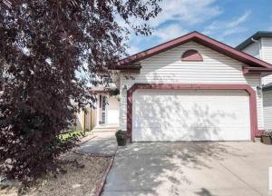 a house with a large white garage door at Cozy Basement Suite close to Downtown,Edmonton in Edmonton
