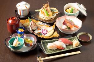 a table with several plates of sushi and chopsticks at HOTEL MYSTAYS PREMIER Kanazawa in Kanazawa