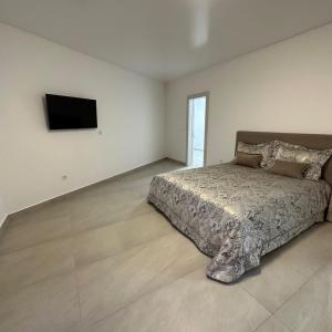 a bedroom with a bed and a flat screen tv at Akapulco Apartments in Bar
