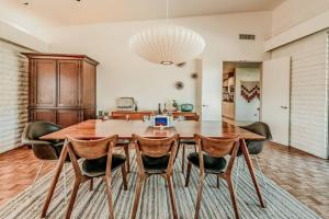 a dining room with a wooden table and chairs at Jacuzzi, Walk to Trails, Stunning Views, Mid-Century Modern,Pool in Sedona