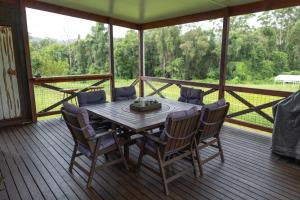 a wooden table and chairs on a screened in porch at Blackwattle Farm in Beerwah