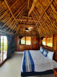 una camera con un grande letto e un soffitto in legno di Casa Sofia Holbox a Isola Holbox