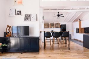 a kitchen with black cabinets and bar stools at Villa Del Mar Omiš in Omiš
