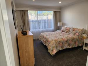 um quarto com uma cama e uma janela em 253 on HIGHGATE em Dunedin