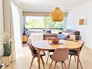 ein Esszimmer und ein Wohnzimmer mit einem Tisch und Stühlen in der Unterkunft Corner apartment near the sea with terrace in Blankenberge