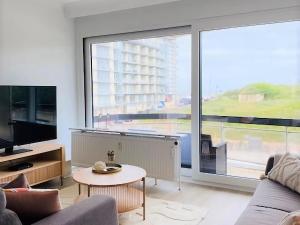ein Wohnzimmer mit einem Sofa und einem großen Fenster in der Unterkunft Corner apartment near the sea with terrace in Blankenberge