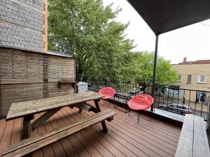 a wooden deck with a picnic table and two chairs at Le Bed & Cocktail - Appartement sur l'Avenue du Mont-Royal in Montreal