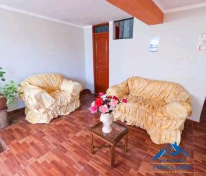 una sala de estar con 2 sillas y un jarrón de flores en Hotel Chota Golf en Chota
