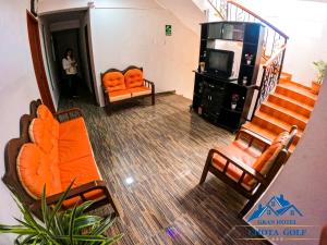 vistas panorámicas a una sala de estar con muebles de color naranja en Hotel Chota Golf en Chota