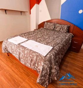 uma cama com um edredão castanho com duas toalhas em Hotel Chota Golf em Chota