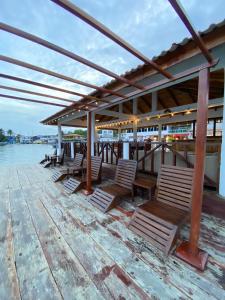 a group of chairs sitting on a wooden dock at Hotel Candy Rose in Colón