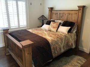 een slaapkamer met een groot bed met een houten hoofdeinde bij Private Lakefront Home in Quiet Residential Area 