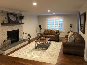sala de estar con 2 sofás y chimenea en Private Lakefront Home in Quiet Residential Area, 