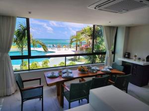 Un comedor con mesa y vista al mar. en Sonho de apartamento pé na areia, en Porto de Galinhas