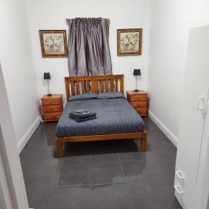 1 dormitorio con 1 cama de madera y 2 mesitas de noche en City Villa 39 Blende st Broken Hill NSW 2880, en Broken Hill