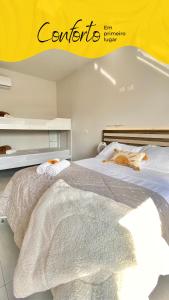 a bedroom with a bed with a white blanket at Pousada Villa Vantino in Penha